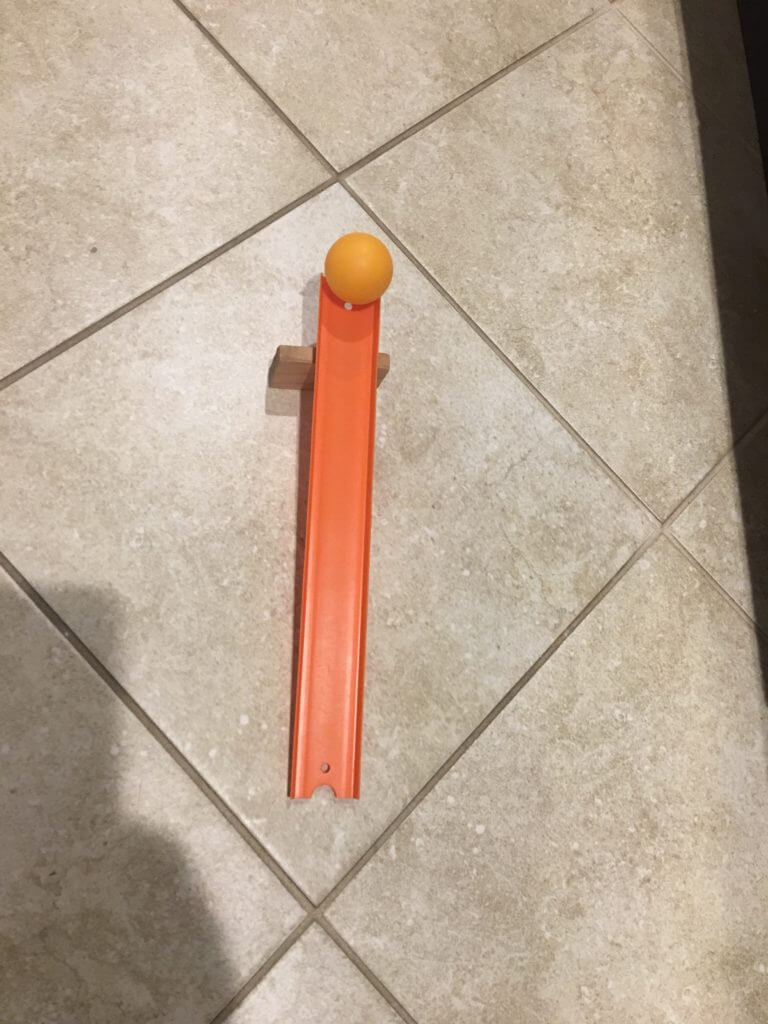 A ball will sit patiently upon the half-circle at the end of a track